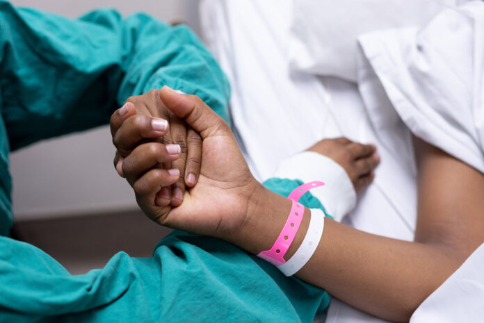 An image of a doctor holding a patients hand.